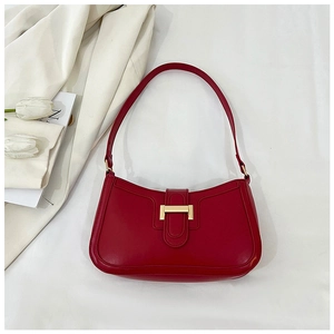 Dettaglio della borsa sottobraccio in pelle rossa con chiusura in metallo dorato a forma di H