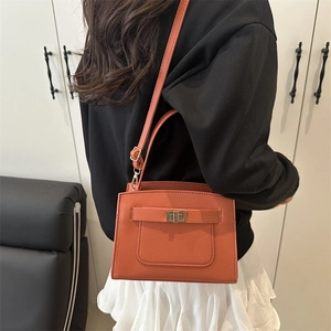 Minimalist orange tote bag in crosshatch PU leather with gold clasp and top handle