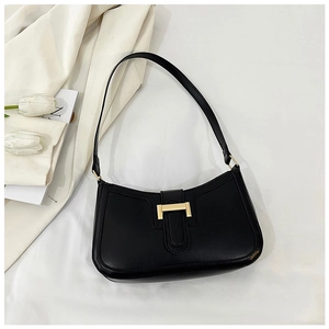 Dettaglio della borsa sottobraccio minimalista in pelle nera con fibbia dorata elegante