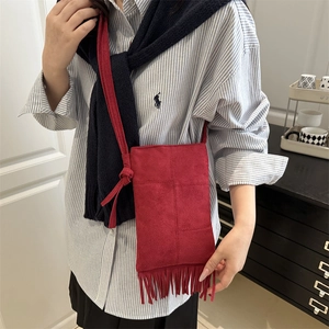 Red faux suede vertical phone bag with tassels and adjustable knotted shoulder strap