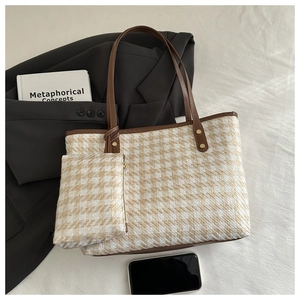 Flat lay of plaid woven tote bag with matching pouch and brown leather handles