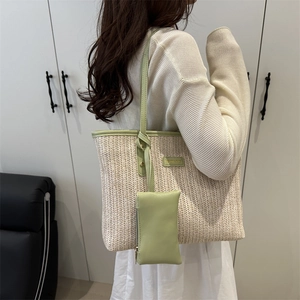 Woven straw tote bag with green leather straps and a small matching pouch for women