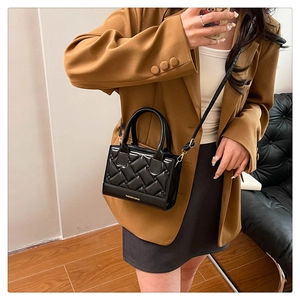 Detail of black quilted leather handbag with Fashion & Bags logo and crossbody strap