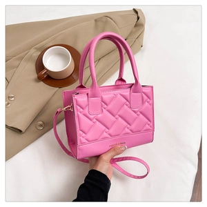 Detailed view of pink quilted handbag with gold FASHION & BAGS print and shoulder strap