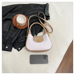 Detail of hobo bag showing woven texture, cream leather trim, and gold hardware