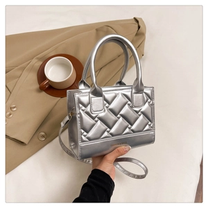 Close-up of silver quilted handbag with diamond pattern next to a khaki coat