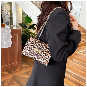 Détail du sac léopard avec bandoulière en chaîne dorée et fermoir rotatif métallique
