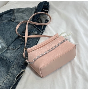 Close-up of pink snake pattern texture with silver chain and leather strap