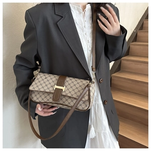 Détail du sac baguette monogramme vintage avec boucle H dorée et bandoulière en cuir