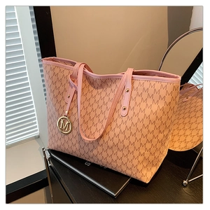 Detailed view of pink tote bag featuring M-letter jacquard pattern and gold metal pendant