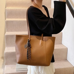 Brown lychee leather tote bag with fashion print and tennis racket charm accessory