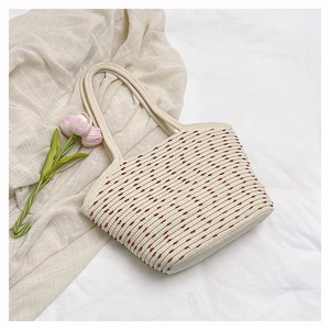 Close-up detail of cream woven tote bag with brown polka dot embroidery and soft texture