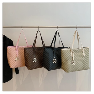 Row of large PU tote bags with monogram pattern and metallic M pendant in four colors