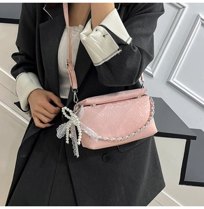 Pink snakeskin patterned crossbody bag with silver chain and pearl bow charm