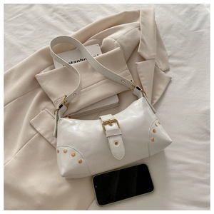 Vue détaillée du sac sous le bras en cuir blanc avec boucle dorée et rivets décoratifs