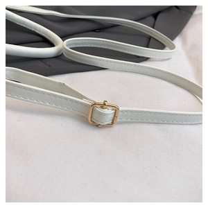 Close-up of white leather shoulder strap with golden buckle and fine stitching detail