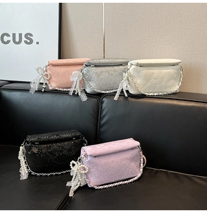 Close-up of small crossbody bags in five colors with snake pattern and pearl bow charms