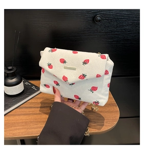 Dettagli della borsa in velluto bianco con stampa di fragole e catena dorata