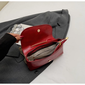 Interior view of red chain bag showing central zipper pocket and open compartment