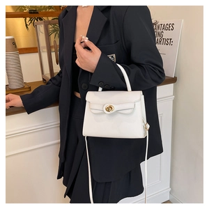 Close-up of a white leather crossbody bag featuring a classic gold twist lock and handle