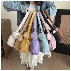 Detailed macro view of corduroy shoulder bags collection with small matching round pouches