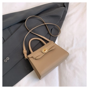 Detail of khaki leather handbag with gold twist lock and adjustable shoulder strap