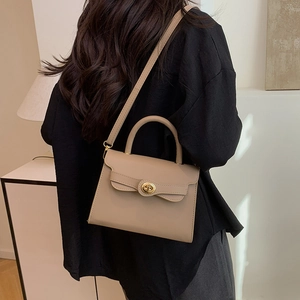 Elegant khaki trapezoidal handbag with gold hardware and shoulder strap for city commuting