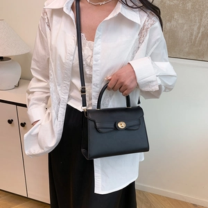 Classic black leather crossbody bag with wave design and gold hardware shown on model