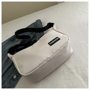 Detail of white nylon crossbody bag with black adjustable strap and FASHION logo patch