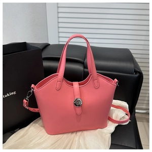 Detail of hot pink bucket bag showing PU leather texture and metal button closure