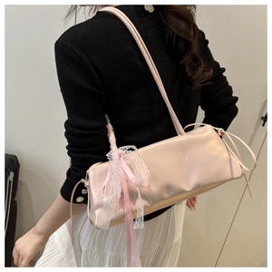 Detail of light pink shoulder bag featuring elegant white lace trim and satin ribbon bow