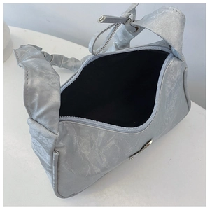 Détail intérieur d'un sac à bandoulière argenté plissé avec fermeture éclair et doublure