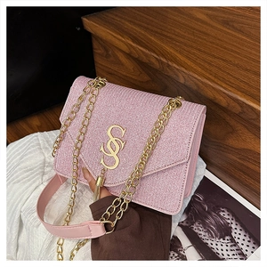 Detailed close-up of pink textured leather bag with gold SSS metal logo and chain strap