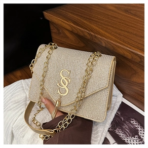 Detailed view of the champagne gold woven bag with S-logo and metallic tassel