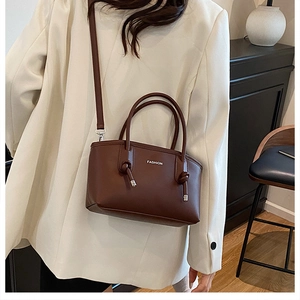 Dettaglio di una borsa in pelle testa di moro con manico annodato e logo di moda