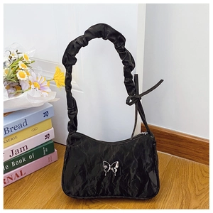 Détail du sac porté épaule noir plissé avec boucle papillon argentée et nœud décoratif