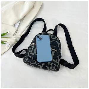 Detailed view of mini logo backpack with metallic zippers next to a smartphone