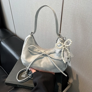 Close-up of velvet hobo bag with pearl bow charm and delicate lace decorative details
