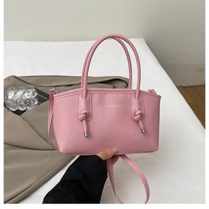 Dettaglio borsa a mano rosa in pelle con stampa FASHION e tracolla regolabile rimovibile