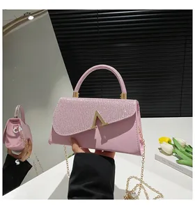 Vue détaillée du sac rose avec strass brillants et boucle métallique dorée en forme de V