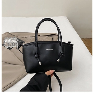 Dettaglio della borsa tote in pelle PU nera con scritta Fashion e manici annodati