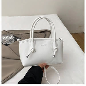 Dettaglio della borsa tote in pelle opaca bianca con manico annodato e scritta FASHION