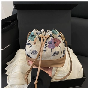 Detail of floral tapestry bucket bag with drawstring closure in a luxury gift box display