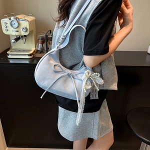 Light blue half-moon shoulder bag with bow detail and pearl lace pendant charm
