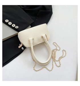 Gros plan du sac coquillage blanc cassé en cuir grainé avec détails de chaîne dorée