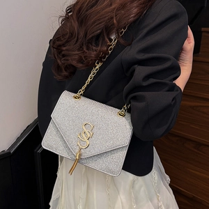 Silver sequin crossbody bag with gold SSS logo and chain strap on female model