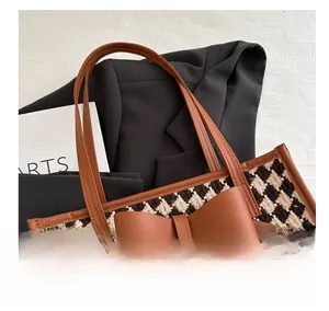 Détail du sac cabas en pied-de-poule avec un grand nœud en cuir marron et finitions