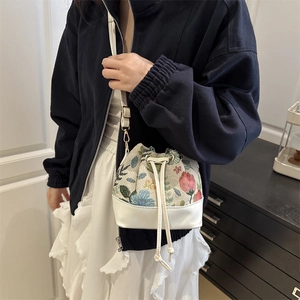 Floral jacquard mini bucket bag with drawstring closure and white leather trim