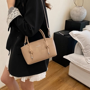 Elegante borsa a tracolla beige con manici e dettaglio annodato portata a spalla