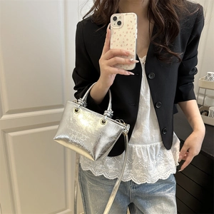 Silver metallic bucket bag with knotted handle and embossed text for fashion styling